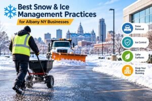 Best snow and ice management practices for Albany NY businesses - worker spreading de-icer while a plow clears a commercial parking lot